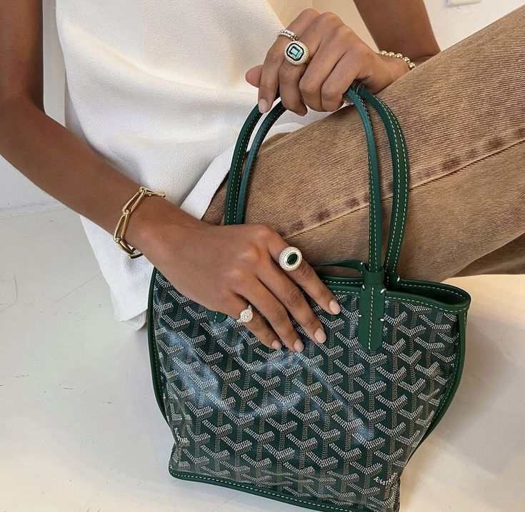 Élodie Mini Tote bag in green geometric pattern held by person with rings and bracelet, compact and chic design