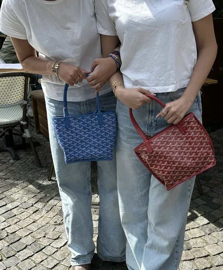 Two women holding Élodie Mini Tote bags in blue and red with geometric patterns and double handles