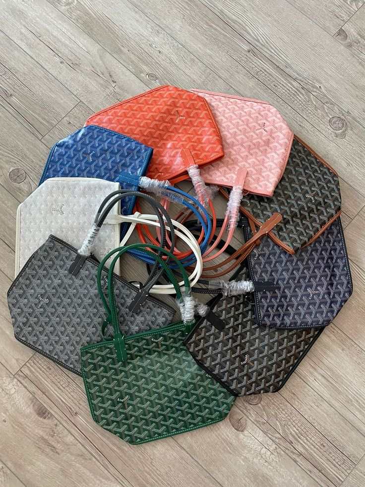 Collection of colorful Élodie Mini Tote bags arranged in a circle on wooden floor showcasing compact geometric patterned mini totes with double handles and detachable pouches.