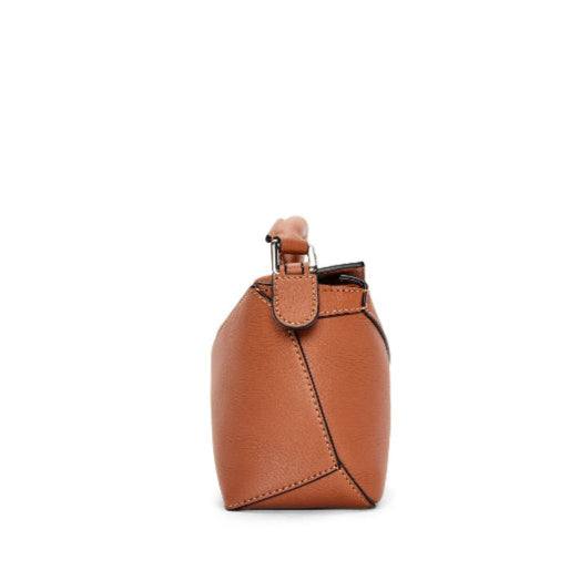 leather handbag side view with geometric puzzle design in brown